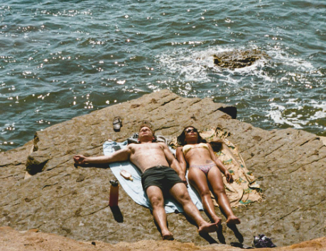 Photo-of-couple-lying-down-on-cliff-near-sea