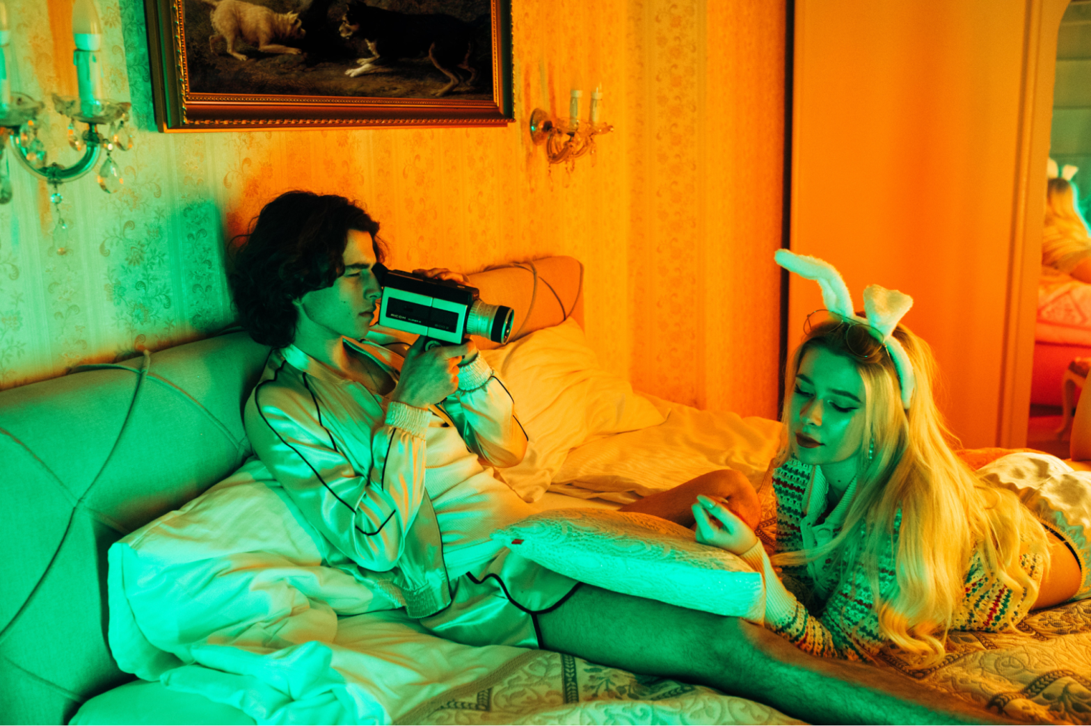 man-filming-woman-in-bed-with-bunny-ears
