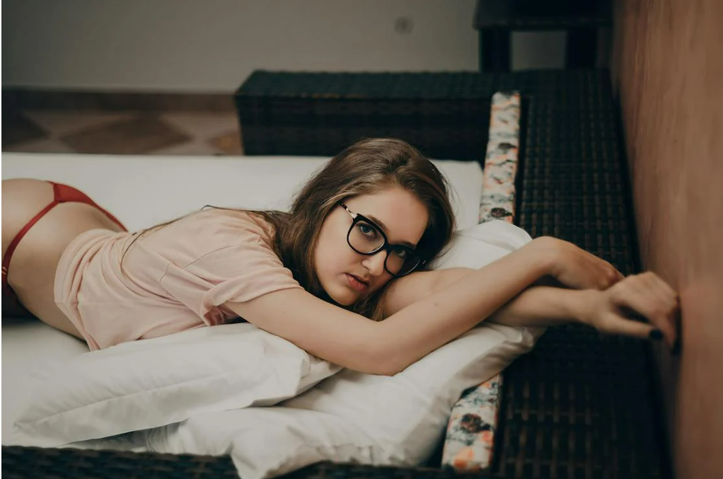 woman-lying-in-beige-crew-neck-shirt-on-bed