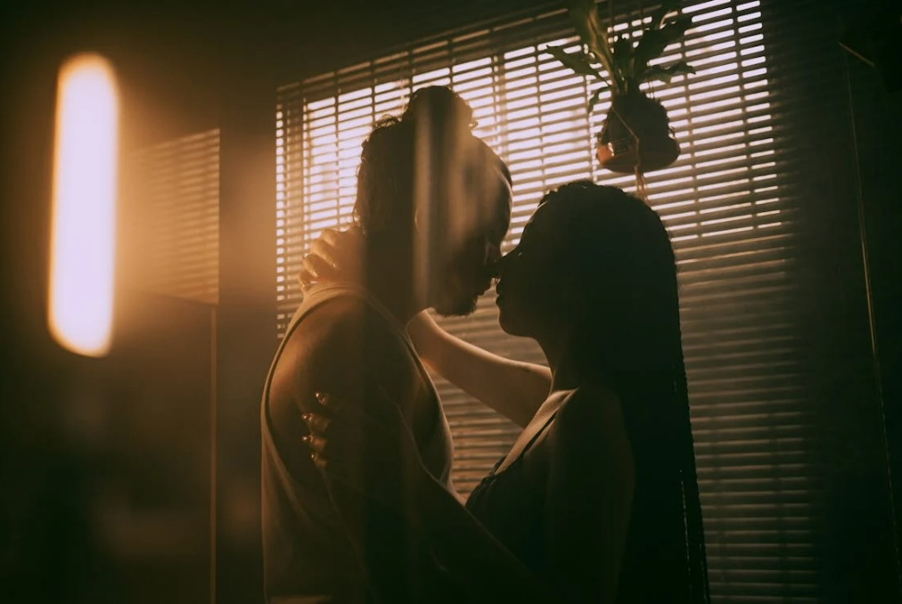 man-kissing-woman-in-dark-room