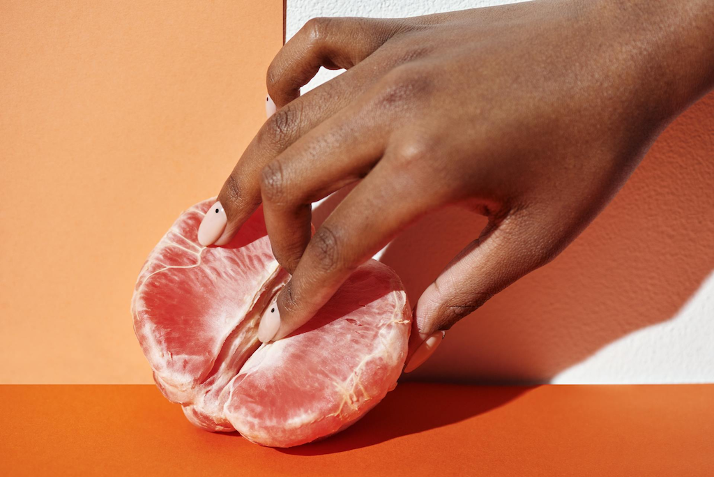 woman-fingering-orange-fruit