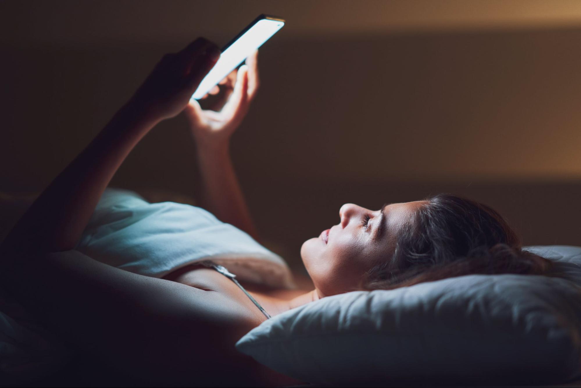 woman in bed at night texting situationship friend