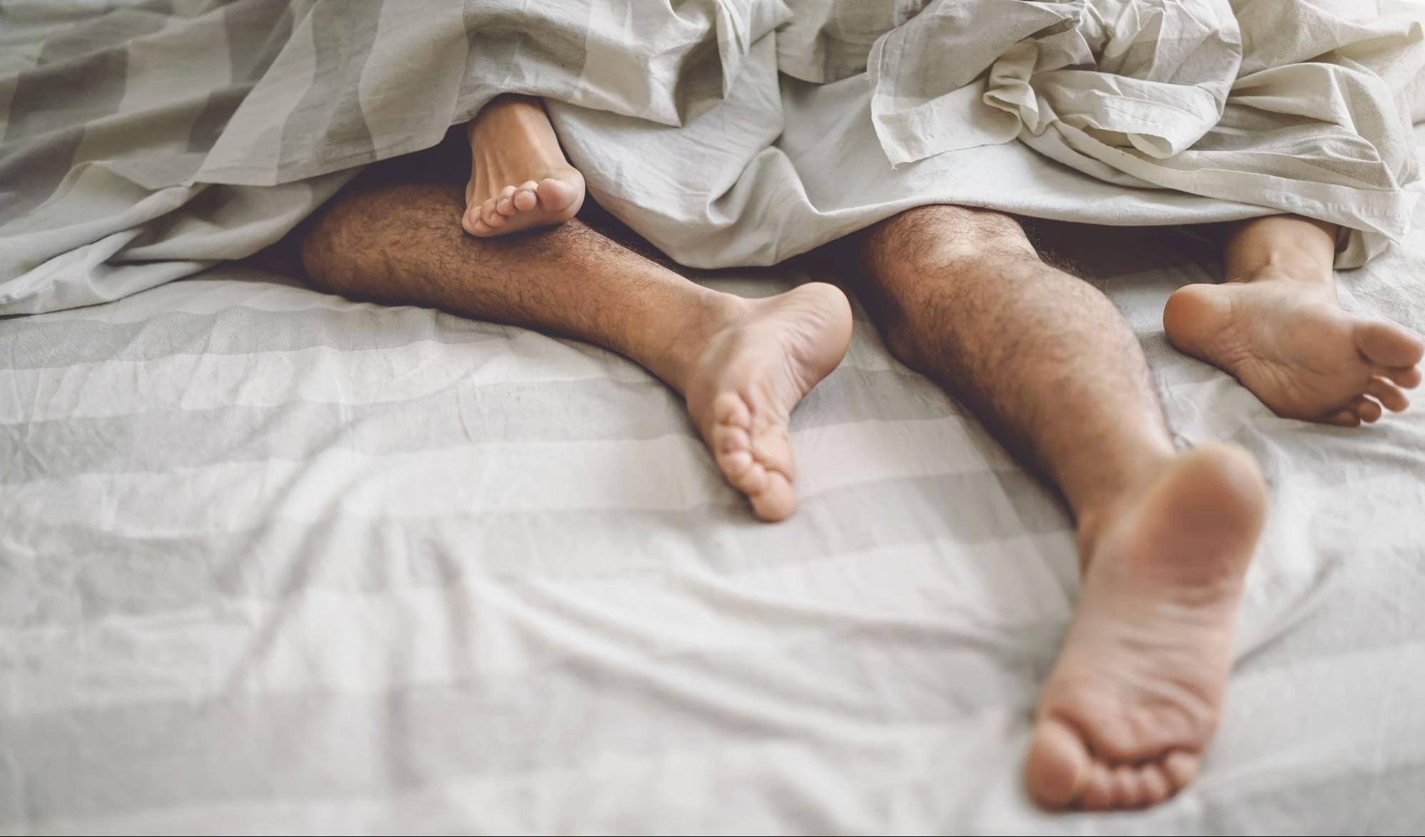 couple in bed under white sheets