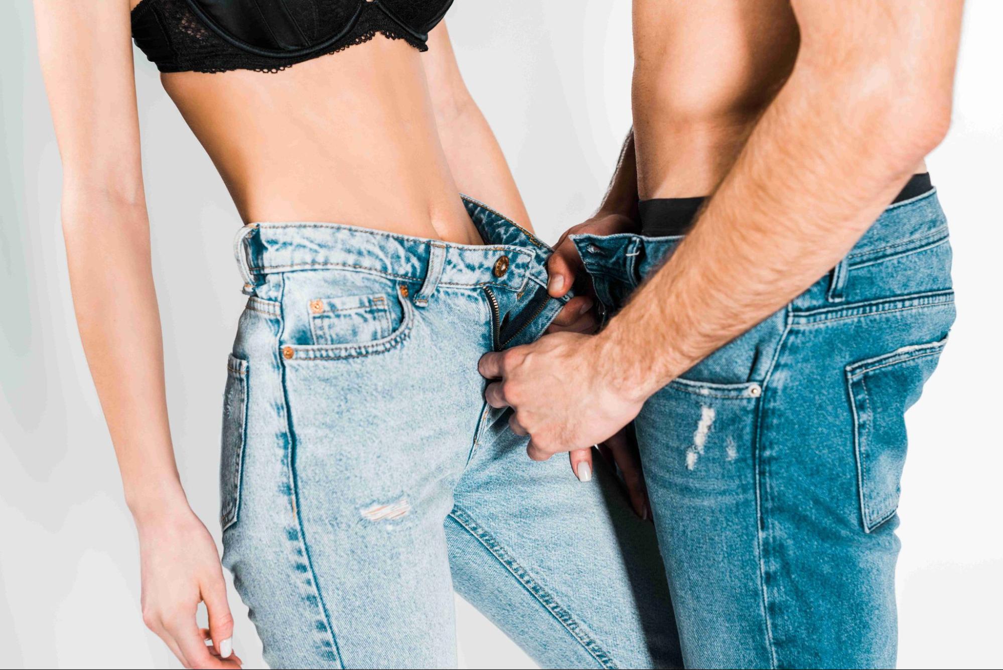 man unzipping girlfriends blue jeans