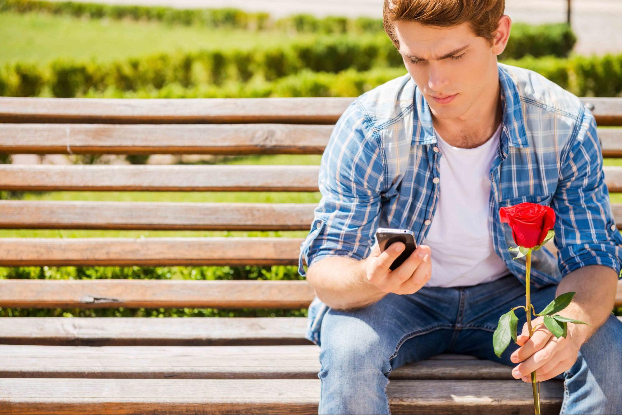 man feeling lonely and rejected with flowers on bench