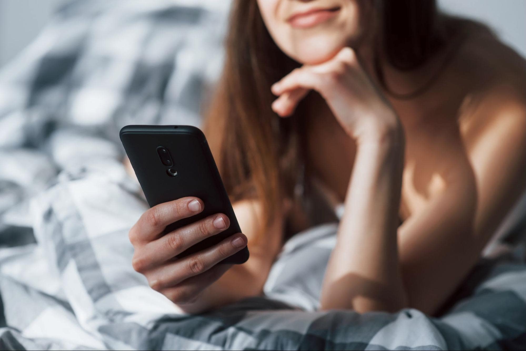 woman-in-bed-using-top-adult-dating-apps-on-phone